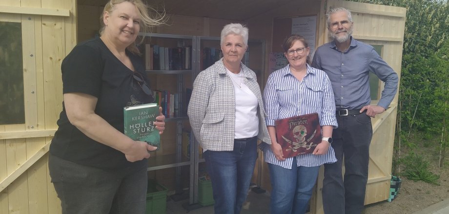 4 Menschen vor einem Bücherschrank