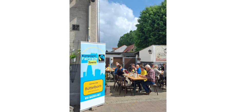Menschen sitzen an Bierzeltgarnitur zum Frühstück