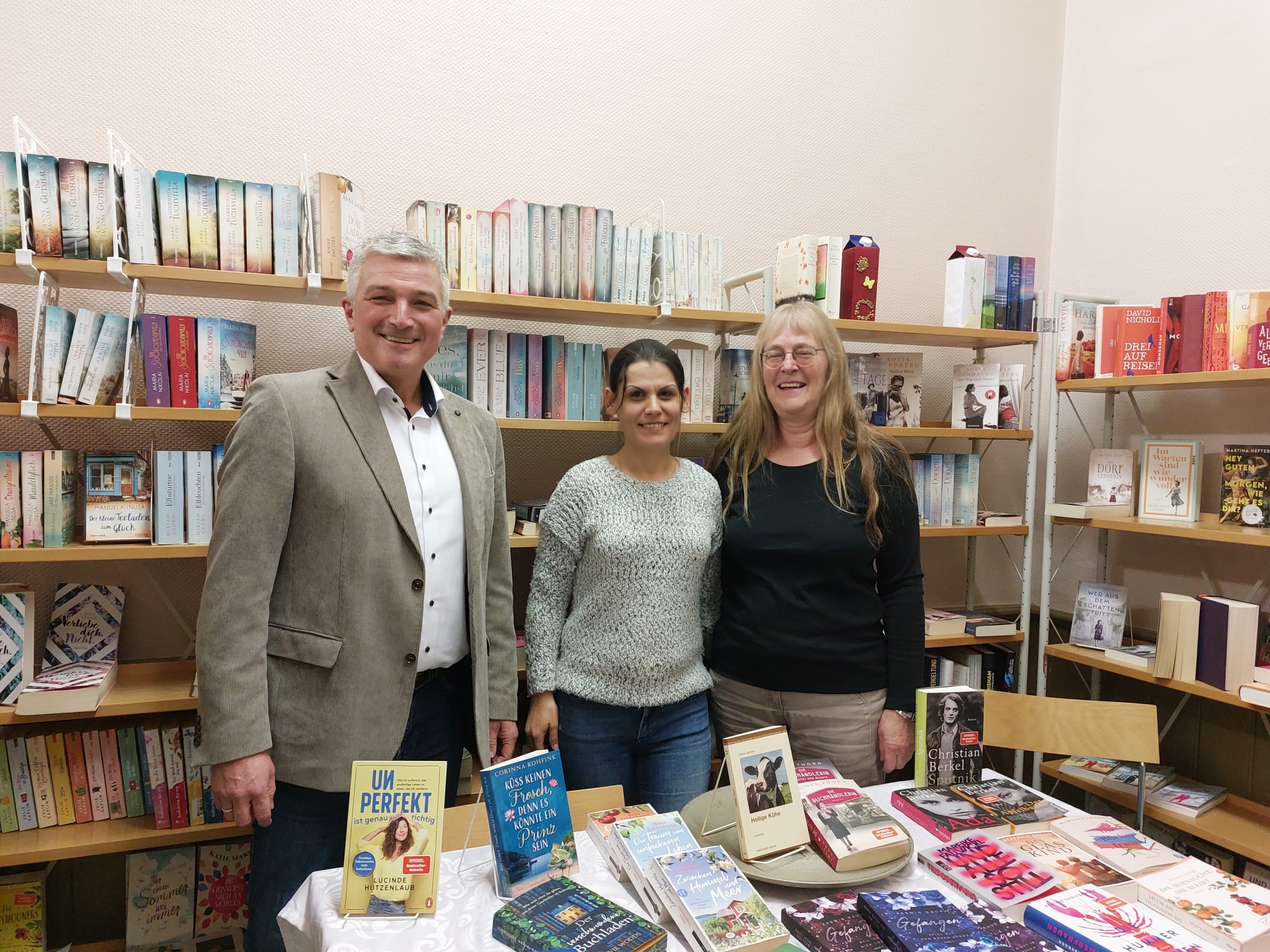 3 Personen in einer Bücherei