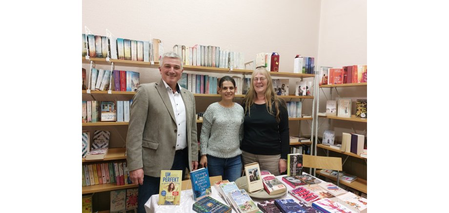 3 Personen in einer Bücherei