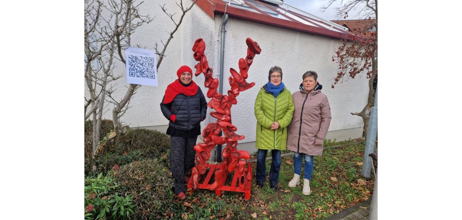 Gruppenbild vor Mahnmal mit roten Schuhen