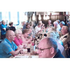 Gäste im Wirtshaus an Tischen