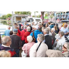 Die Reisegruppe steht vor einem Fahrkartenschalter am Schiffsableger