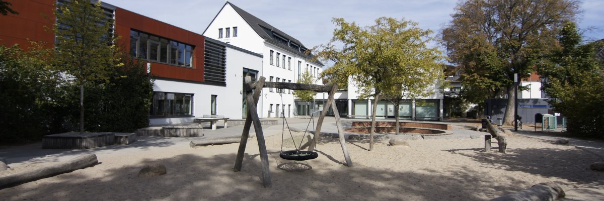Foto: Schulhof Pestalozzi-Schule Büttelborn mit Gebäude und Schaukel