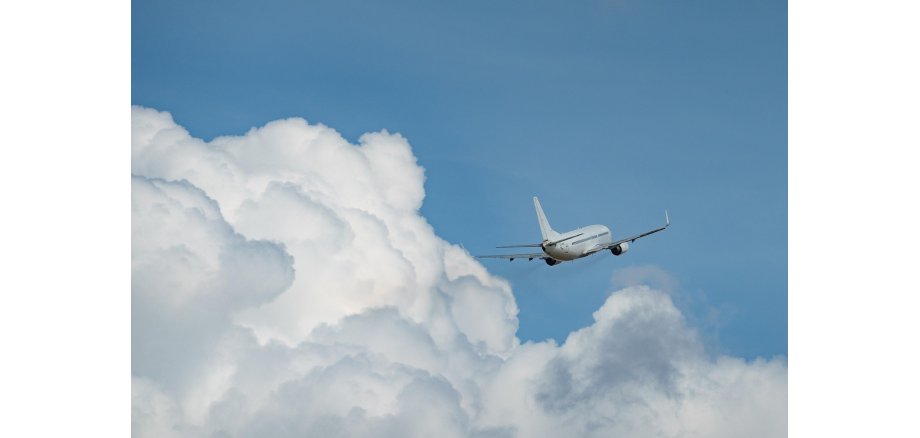 Flugzeug am Himmel mit Wolken 